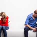 Frustrated couple sitting apart on a sofa