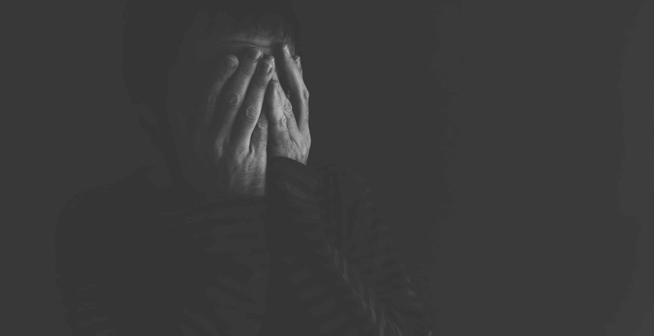 Person with hands on face, showing distress