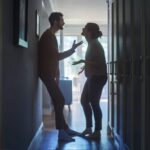 Two people arguing in a hallway