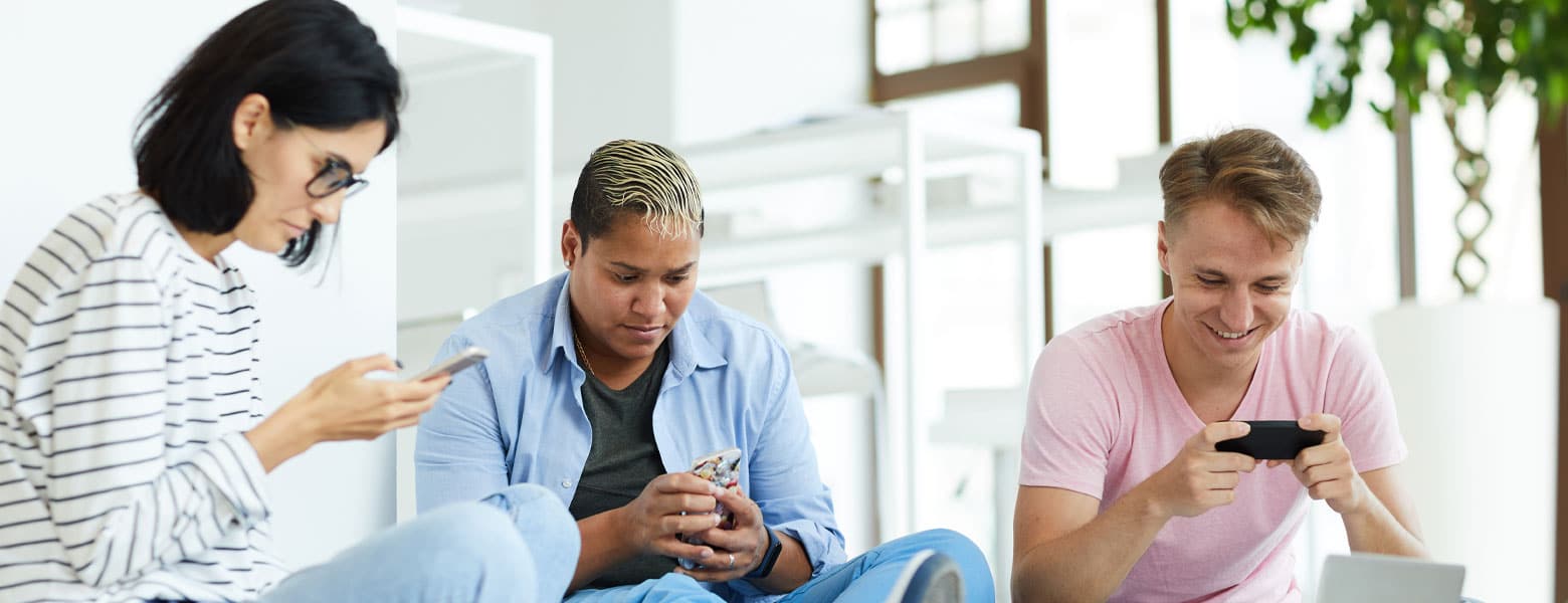 three adults using their phone